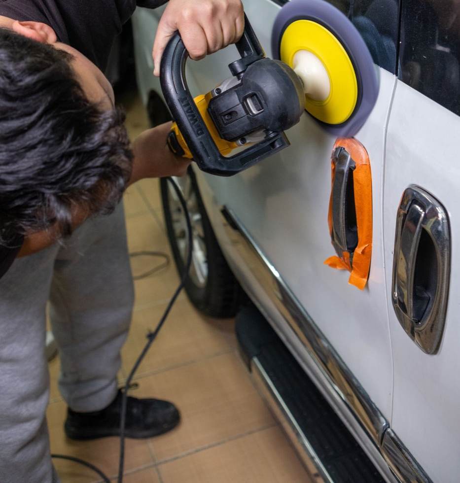 Polissage d'une carrosserie blanche, poignées protégées au ruban de masquage